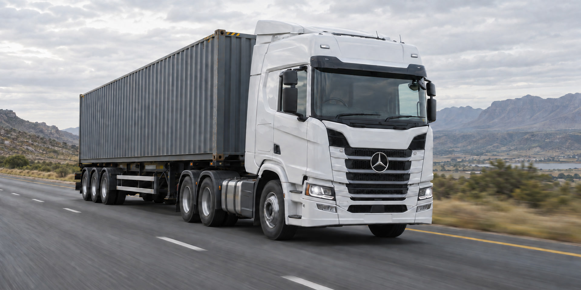 Right-hand-drive white Mercedes-Benz tractor hauling a 40-foot shipping container
